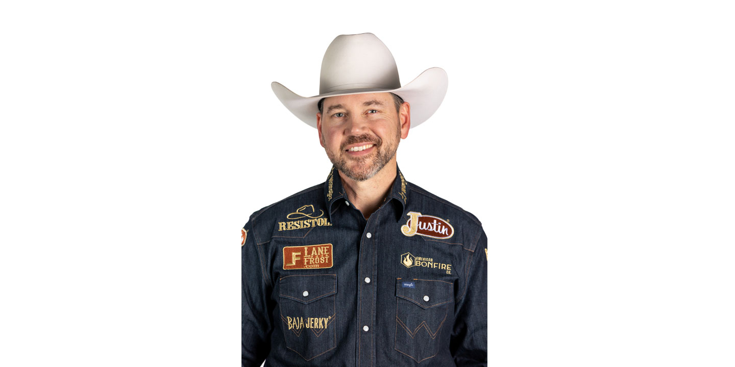 El barrendero profesional Matt Merritt, vestido con una camisa vaquera, un sombrero de vaquero blanco y sonriendo, frente a una pared blanca.